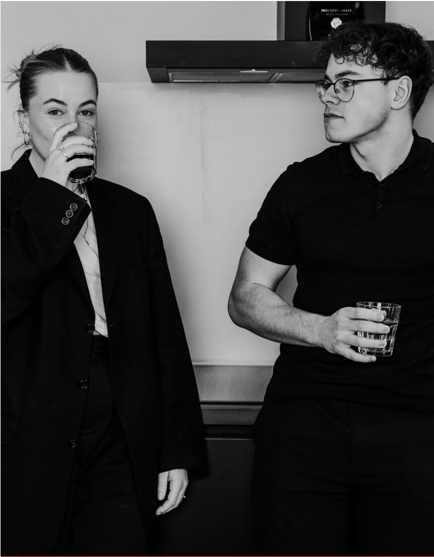Two people standing and drinking coffee