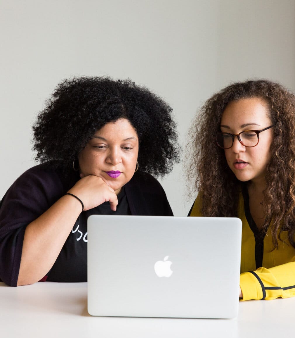 Two women looking at a laptop